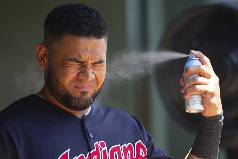 ARCHIVO – El jardinero derecho de los Cleveland Indians, Melky Cabrera, se aplica protector solar antes de un partido de béisbol contra los Texas Rangers, el domingo 22 de julio de 2018, en Arlington, Texas. (AP Foto/Sam Hodde, Archivo)