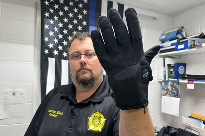 Justin Hall, custodio de la cárcel del condado de Nelson, en Kentucky, muestra un guante de electrochoques que se utiliza en la instalación, el jueves 13 de agosto de 2026, en Bardstown, Kentucky. (AP Foto/Dylan Lovan)