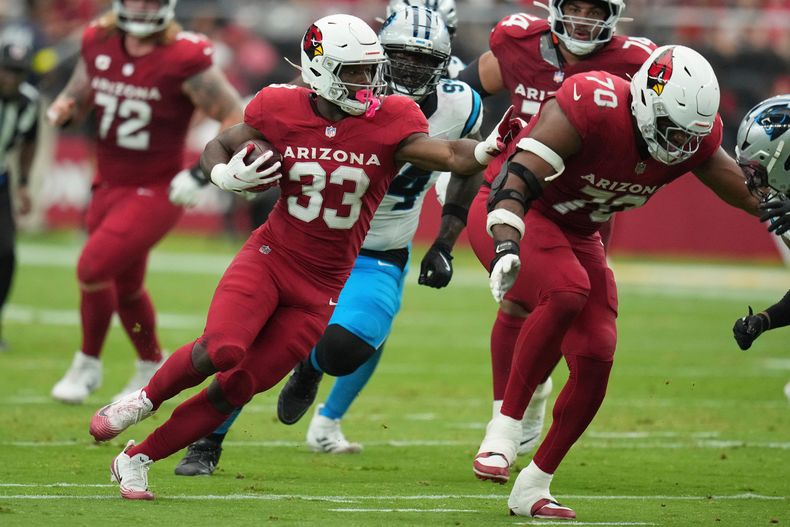 El corredor de los Cardinals de Arizona, Trey Benson (33), corre contra los Panthers de Carolina durante la primera mitad de un juego de fútbol americano de la NFL, el domingo 14 de septiembre de 2025, en Glendale, Arizona. (AP Photo/Rick Scuteri)