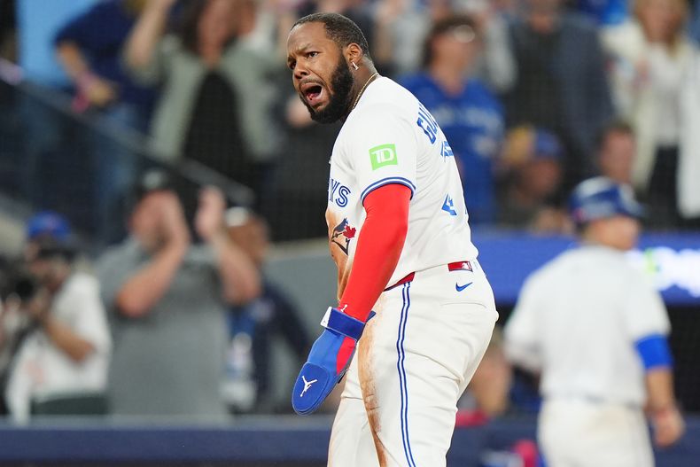 Vladimir Guerrero Jr. (27), de los Azulejos de Toronto, celebra después de anotar gracias a un error de tiro en tercera base por parte del receptor de los Marineros de Seattle, Cal Raleigh (no en la imagen) durante la séptima entrada del sexto juego de la Serie de Campeonato de la Liga Americana, el domingo 19 de octubre de 2025, en Toronto. (Frank Gunn/The Canadian Press via AP)