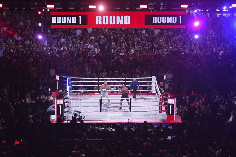 Jake Paul, a la izquierda, y Mike Tyson pelean durante su combate de boxeo de peso pesado, el viernes 15 de noviembre de 2024, en Arlington, Texas. (AP Foto/Julio Cortez)