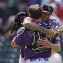 Kyle Freeland, derecha, abridor de los Rockies de Colorado, abraza al receptor Brett Sullivan, después de que forzara a un out con un elevado a Tyler Tolbert para terminar el juego con al lanzar la ruta completa, en el juego de béisbol de Grandes Ligas del domingo 2 de agosto de 2026, en Denver. (AP Foto/David Zalubowski)