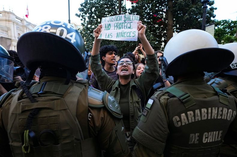 Activistas feministas protestan frente al Ministerio de Justicia por la reducción de penas impuestas a personas condenadas por delitos sexuales contra menores, en Santiago de Chile, el martes 27 de octubre de 2026. (Foto AP/Esteban Félix)