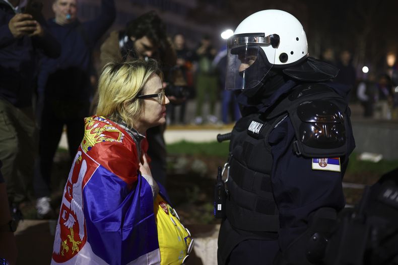 Una manifestante habla con un oficial durante una gran manifestación contra el presidente populista Aleksandar Vucic y su gobierno, en el centro de Belgrado, Serbia, el sábado 15 de marzo de 2025. (AP Foto/Armin Durgut)
