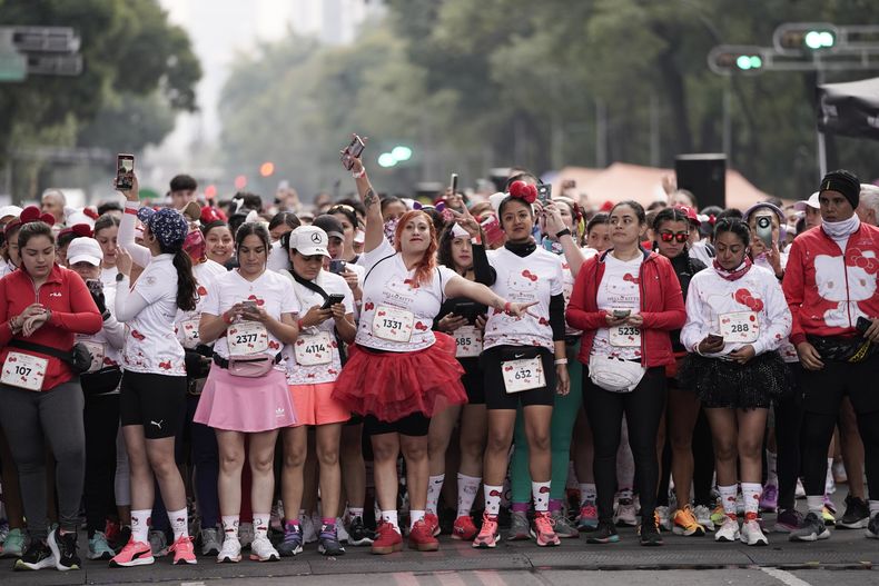 Fans del personaje japonés Hello Kitty se preparan para una carrera, durante la celebración del 50 aniversario del personaje, en la Ciudad de México, el domingo 13 de octubre de 2024. (Foto AP/Aurea Del Rosario)
