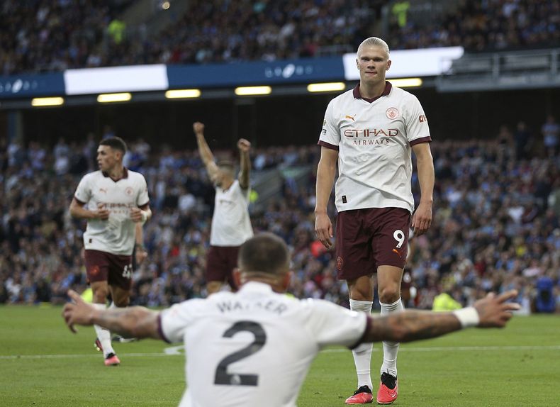 Erling Haaland, del Manchester City, celebra después de anotar el segundo gol de su equipo en el partido con su compañero Kyle Walker, durante el partido de fútbol de la Liga Premier entre Manchester City y Burnley FC en Turf Moor, Burnley, Inglaterra, el viernes 11 de agosto de 2023. (Nigel French/PA vía AP)