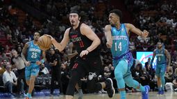 El armador mexicano del Heat de Miami Jaime Jaquez Jr. (11) conduce hacia el aro mientras defiende el base de los Hornets de Charlotte Ish Smith (14) durante la 1ra mitad del juego de baloncesto de la NBA, el domingo 14 de enero de 2024, en Miami. (AP Foto/Lynne Sladky)