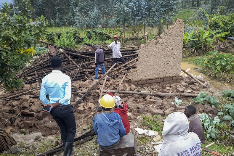 Varias personas se reúnen junto a un edificio colapsado luego de una inundación en el distrito de Nyabihu, en la provincia Oeste de Ruanda, el miércoles 3 de mayo de 2023. (AP Foto/Rachid Bugirinfura)