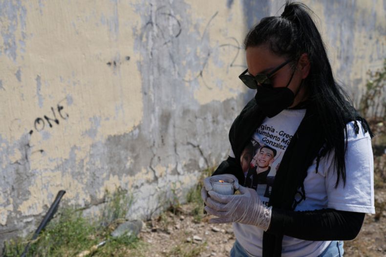 Una familiar de una persona desaparecida, parte de un grupo llamado Guerreros Buscadores, enciende una vela tras encontrar restos óseos enterrados en Tlajomulco de Zúñiga, a las afueras de Guadalajara, México, el martes 24 de marzo de 2026. (AP Foto/Eduardo Verdugo)