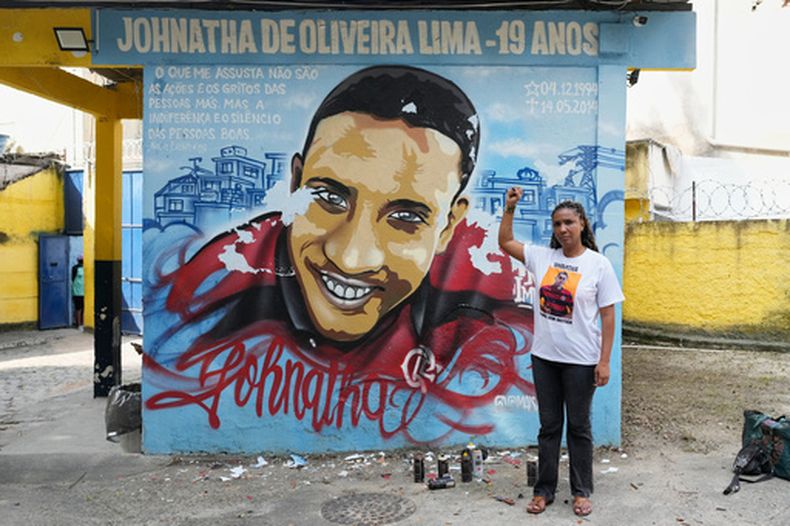 Ana Paula Oliveira frente a un mural en memoria de su hijo Johnatha, muerto por la policía en Río de Janeiro, el 14 de mayo del 2026. (AP foto/Silvia Izquierdo)