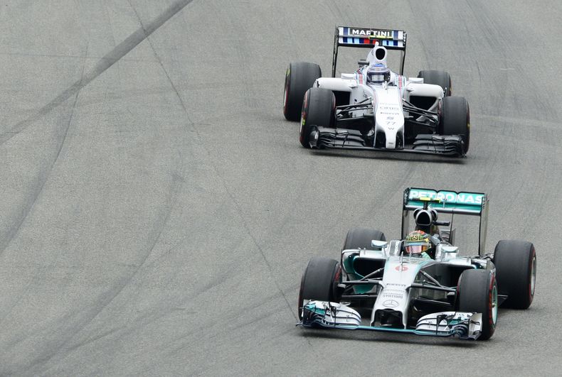 El piloto de Mercedes Nico Rosberg toma una curva por delante de Valtteri Bottas, de Williams, durante el Gran Premio de Alemania de F&ouml;rmula Uno el domingo, 20 de julio del 2014. (Foto AP/Jens Meyer)