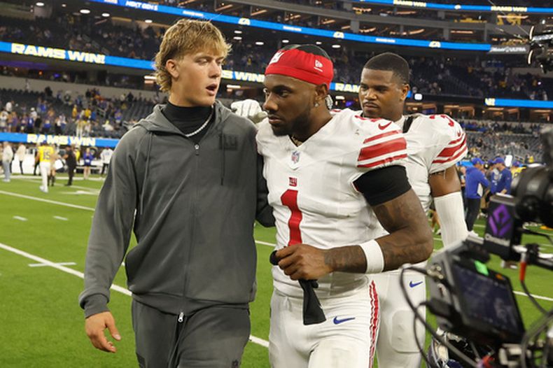El quarterback Jaxson Dart (izquierda) de los Giants de Nueva York camina fuera del campo junto a Malik Nabers (1) tras el partido contra los Rams de Los Ángeles, el lunes 21 de septiembre de 2026, en Inglewood, California. (AP Foto/Caroline Brehman)