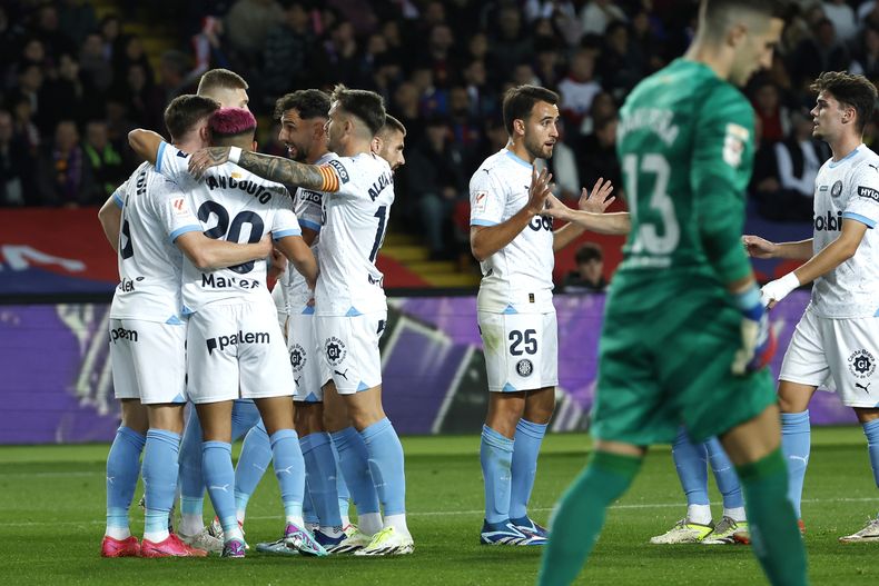 Jugadores de Girona celebra el tanto para abrir el marcador de Artem Dovbyk en el encuentro ante el Barcelona en la liga española en el estadio Olimpic Lluis Companys el domingo 10 de diciembre del 2023. (AP Foto/Joan Monfort)