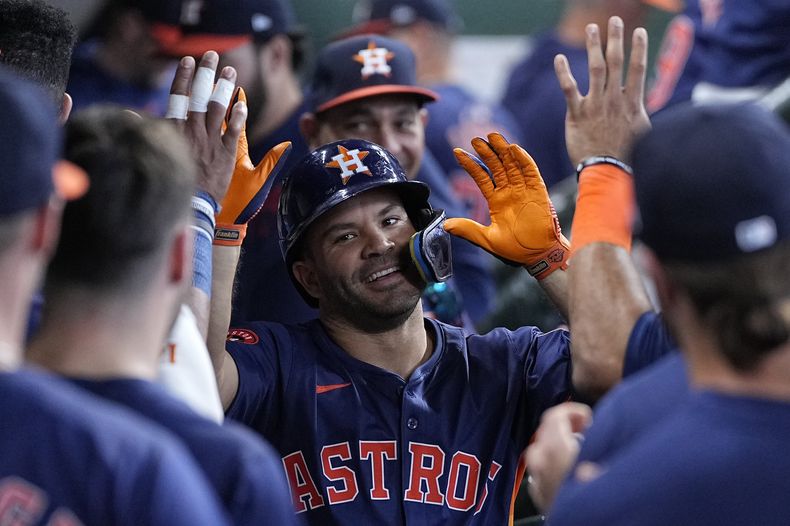 El venezolano José Altuve es felicitado en el dugout por sus compañeros tras pegar un jonrón solitario en la tercera entrada ante los Rangers de Texas el domingo 14 de abril del 2024. (AP Foto/Kevin M. Cox)
