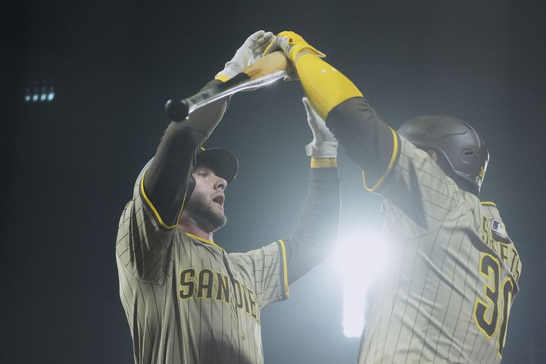 Jackson Merrill (izquierda), de los Padres de San Diego, es felicitado por Gavin Sheets luego de batear un jonrón ante los Gigantes de San Francisco, el martes 12 de agosto de 2025 (AP Foto/Jeff Chiu)