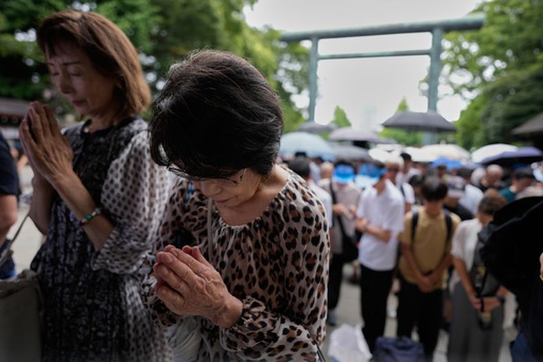 Visitantes guardan un minuto de silencio en el santuario de Yasukuni, que rinde homenaje a los japoneses caídos en guerras, incluidos criminales de guerra condenados, en el 81º aniversario del final de la II Guerra Mundial, el sábado 15 de agosto de 2026 en Tokio. (AP Foto/Eugene Hoshiko)