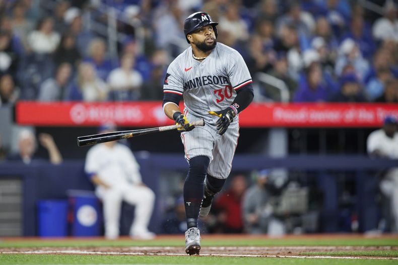 El dominicano Carlos Santana, de los Mellizos de Minnesota, conecta un jonrón ante los Azulejos de Toronto, el viernes 10 de mayo de 2024 (Cole Burtson/The Canadian Press via AP)