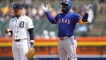 El jardinero de los Rangers de Texas Adolis García, derecha, cuestiona si su batazo era un cuadrangular, mientras que el campocorto Javier Báez (28), de los Tigres de Detroit, observa la pelota en la sexta entrada del juego de béisbol, el miércoles 17 de abril de 2024, en Detroit. A Garcia le acreditaron un doble. (AP Foto/Paul Sancya)