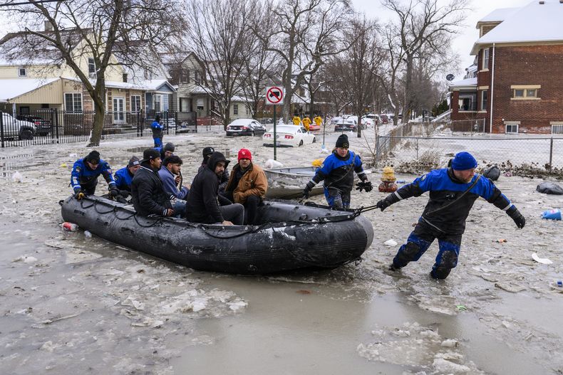 Miembros del Equipo de Buceo del Sureste de Michigan ponen a salvo a varias personas luego de que la ruptura de una tubería principal de agua provocó inundaciones masivas, el lunes 17 de febrero de 2025, en Detroit. (Andy Morrison/Detroit News vía AP)
