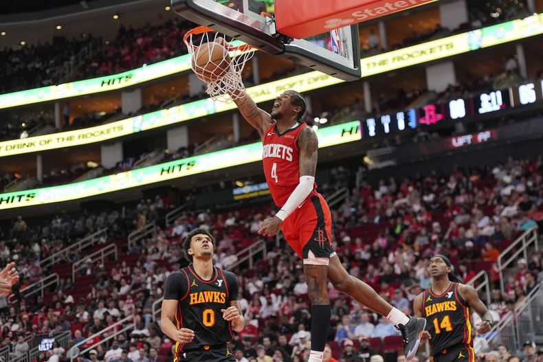 Jalen Green de los Rockets de Houston clava el balón frente a Dominick Barlow de los Hawks de Atlanta en el encuentro del martes 25 de marzo del 2025. (AP Foto/David J. Phillip)