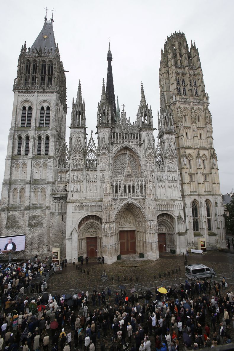 ARCHIVO - Una multitud se reúne en torno a la catedral de Ruan, Normandía, durante la misa funeral por el padre Hamel, el martes 2 de agosto de 2016. Las autoridades francesas reportaron un incendio en la aguja de la catedral medieval de Ruan. (AP Foto/Michel Euler, Archivo)