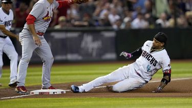 El dominicano Ketel Marte, de los Diamondbacks de Arizona, se desliza en la antesala con un triple ante Nolan Arenado, de los Cardenales de San Luis, el martes 25 de julio de 2023 (AP Foto/Matt York)