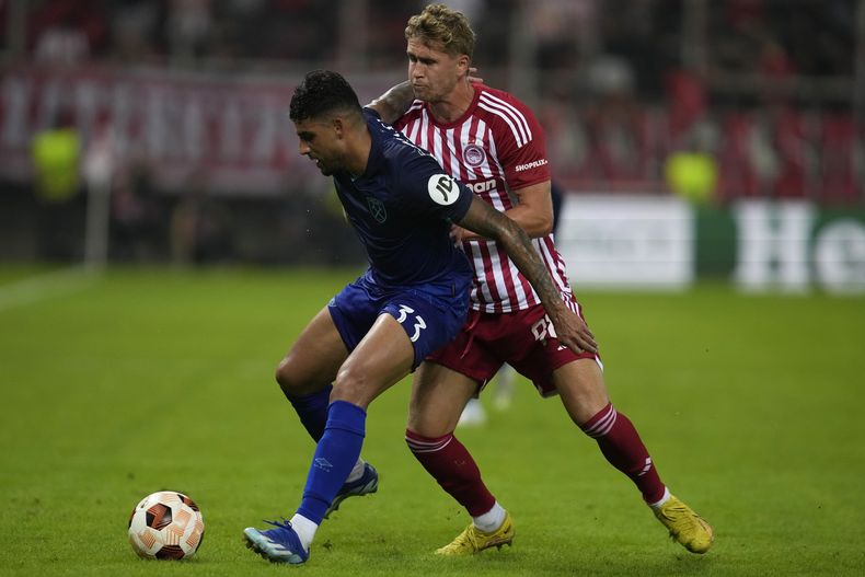 Ola Solbakken del Olympiacos defiende a Emerson Palmieri del West Ham en el encuentro del Grupo A de la Europa League el jueves 26 de octubre del 2023. (AP Foto/Thanassis Stavrakis)