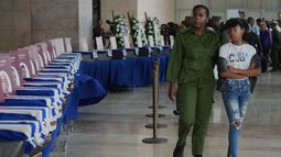 Mujeres pasan junto a las urnas con los restos de los militares cubanos que murieron durante la operación estadounidense en Venezuela para capturar al expresidente venezolano Nicolás Maduro, en el Ministerio de las Fuerzas Armadas Revolucionarias en La Habana, Cuba, el jueves 15 de enero de 2026. (Foto AP/Ramón Espinosa