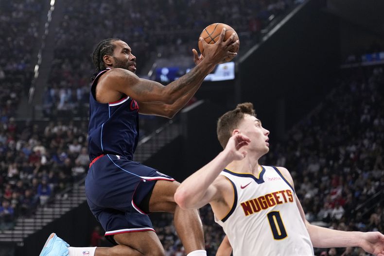 El alero de los Clippers de Los Ángeles Kawhi Leonard salta para anotar frente al base Chrstian Braun de los Nuggets de Denver el jueves 24 de abril del 2025. (AP Foto/Mark J. Terrill)