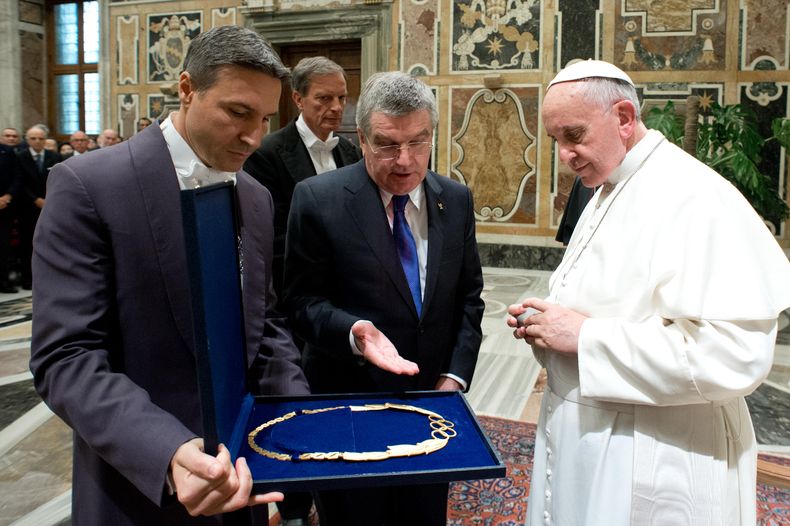 El papa Francisco, derecha, recibe un regalo del presidente del COI, Thomas Bach, centro, en una ceremonia en el Vaticano el s&aacute;bado, 23 de noviembre de 2013. Imagen suministrada por el diario del vaticano LOsservatore. (AP Photo/L Osservatore Rom