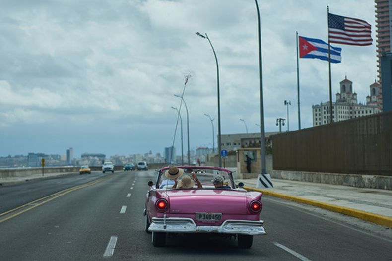 Un auto clásico estadounidense lleva a turistas junto a la embajada de Estados Unidos en La Habana, el lunes 20 de abril de 2026. (AP Foto/Ramón Espinosa)