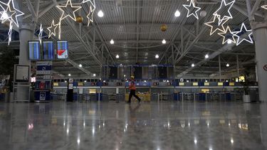 americateve | Un empelado pasa por delante de mostradores de facturaci&oacute;n vac&iacute;os durante una huelga general nacional de 24 horas, en el aeropuerto Eleftherios Venizelos en Spata, cerca de Atenas, el 27 de noviembre de 2014. (Foto AP/Kostas Tsironis)