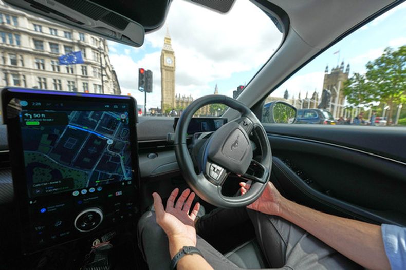 Un conductor de Uber, con las manos listas para intervenir, sentado en un auto de conducción autónoma en Londres, el 1 de septiembre de 2026, en vísperas de que la plataforma lance sus primeros taxis autónomos en la ciudad. (AP Foto/Frank Augstein)