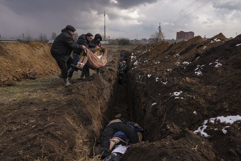 Cuerpos son colocados en una fosa común en las afueras de Mariúpol, Ucrania, el miércoles 9 de marzo de 2022. (AP Foto/ Evgeniy Maloletka)