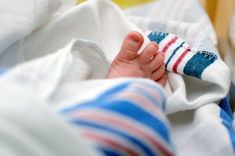 ARCHIVO – Los dedos del pie de un bebé asoman desde una manta en un hospital en McAllen, Texas, el 29 de julio de 2020. (AP Foto/Eric Gay, Archivo)