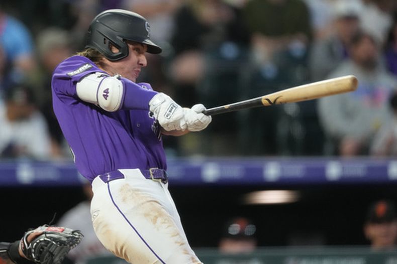 Jake McCarthy, de los Rockies de Colorado, conecta un jonrón de dos carreras ante el lanzador abridor de los Gigantes de San Francisco, Adrian Houser, en la cuarta entrada de un partido de béisbol el sábado 30 de mayo de 2026, en Denver. (Foto AP/David Zalubowski)