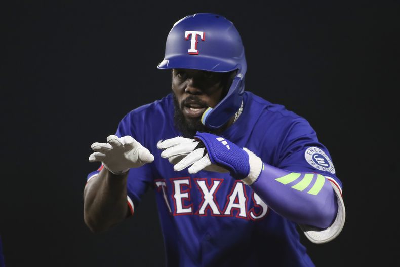 El cubano Adolis García, de los Rangers de Texas, festeja luego de pegar un sencillo ante los Atléticos de Oakland, el martes 22 de abril de 2025 (AP Foto/Scott Marshall)