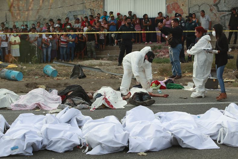 ARCHIVO - Varios cuerpo en bolsas para cadáveres colocados en un lado de la carretera tras el accidente mortal de un tráiler que llevaba migrantes en Tuxtla Gutiérrez, en el estado de Chiapas, México, el 9 de diciembre de 2021. (AP Foto, Archivo)