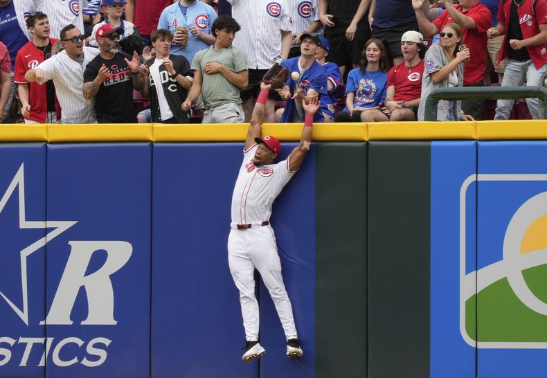 El jardinero derecho de los Rojos de Cincinnati, Will Benson, falla al intentar quedarse con jonrón solitario de Reese McGuire, de los Cachorros de Chicago, en la segunda entrada el domingo 25 de mayo de 2025, en Cincinnati. (AP Foto/Carolyn Kaster)