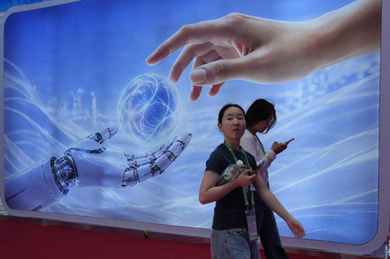 Visitantes caminan junto a un cartel con una mano humana y una robótica en la Expo Internacional China de Cadena de Suministro en Beijing, el lunes 22 de junio de 2026. (AP Foto/Ng Han Guan)