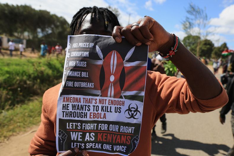 Un manifestante sostiene un cartel durante una protesta contra el establecimiento, por parte de Estados Unidos, de un centro de cuarentena contra el ébola en la base aérea Laikipia, en Nanyuki, Kenia, el 1 de junio de 2026. (AP Foto/Andrew Kasuku)