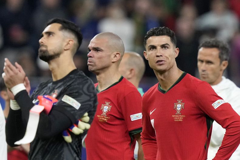 Diogo Costa, Pepe y Cristiano Ronaldo, de la selección portuguesa, se lamentan tras la derrota ante Francia por penales en los cuartos de final de la Eurocopa, el viernes 5 de julio de 2024, en Hamburgo, Alemania (AP foto/Martin Meissner)