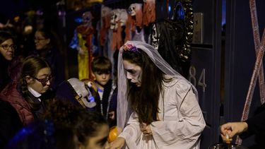 Personas disfrazadas con trajes terroríficos participan en una celebración de Halloween en la que se reparten dulces a los niños en Paracuellos del Jarama, España, el viernes 31 de octubre de 2025. (Foto AP/Manu Fernández)