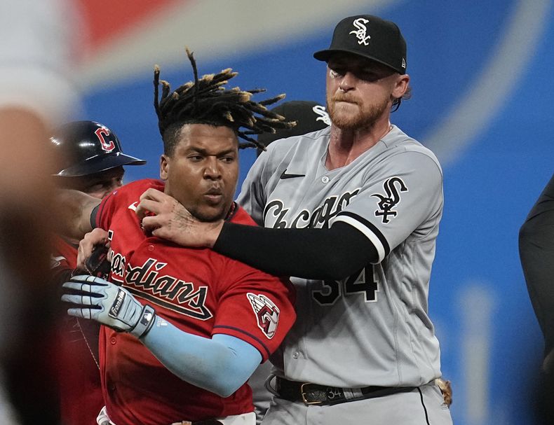 En foto del sábado 5 de agosto del 2023, Michael Kopech de los Medias Blancas de Chicago sostiene al dominicano José Ramírez de los Guardianes de Cleveland durante una pelea con Tim Anderson. (AP Foto/Sue Ogrocki)