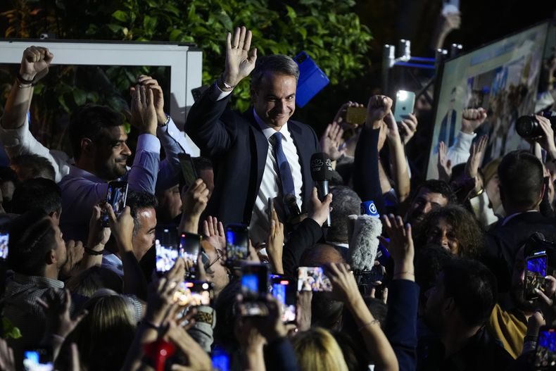 El primer ministro de Grecia y líder de Nueva Democracia, Kyriakos Mitsotakis, en el centro, se dirige a sus seguidores en la sede de su partido en Atenas, Grecia, el domingo 21 de mayo de 2023. El partido conservador de Mitsotakis ganó las elecciones por abrumadora mayoría, aunque sin suficientes escaños como para formar un gobierno. (AP Foto/Thanassis Stavrakis)