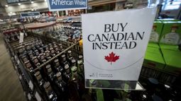 Un letrero frente a la sección de whisky estadounidense en una licorería de Columbia Británica, Canadá, recomienda comprar productos nacionales, en Vancouver, el 2 de febrero de 2025. (Ethan Cairns/The Canadian Press vía AP)