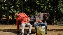 Personas bajo la influencia de sustancias desconocidas duermen en un banco afuera de una iglesia donde ocasionalmente reciben alimentos donados en La Habana, Cuba, el martes 24 de febrero de 2026. (AP Foto/Ramón Espinosa)