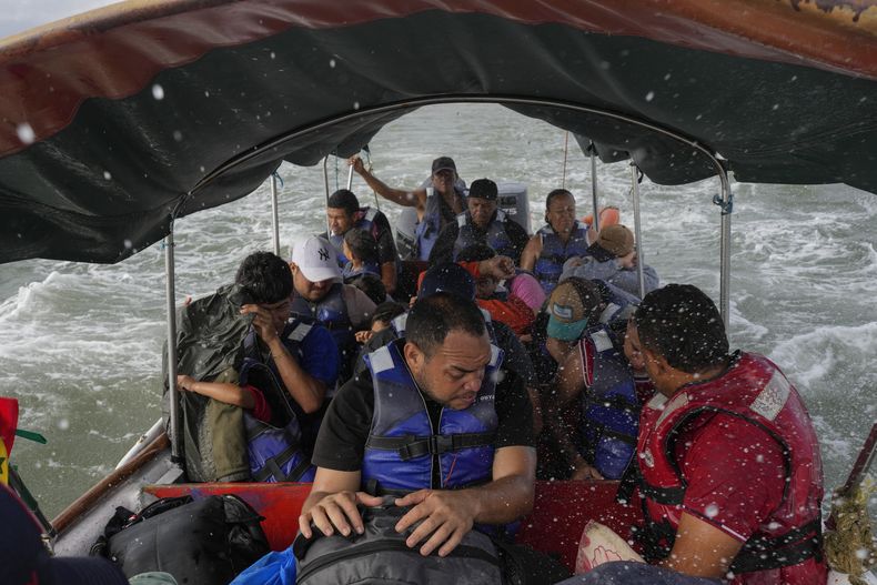 Luis Sánchez, centro, con otros migrantes venezolanos en un bote en Gardi Sugdub en la costa caribeña de Panamá el 23 de febrero del 2025. (AP foto/Matias Delacroix)