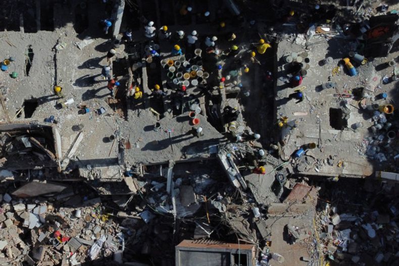 Voluntarios y rescatistas utilizan cubos para retirar los escombros de un edificio derrumbado un día después de un sismo que remeció Cali, Colombia, el 11 de agosto de 2026. (AP Foto/Santiago Saldarriaga)