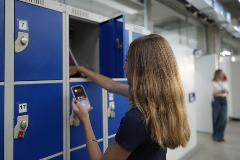 Una alumna guarda su teléfono en un casillero en la escuela de Porto Seguro, en Sao Paulo, el jueves 6 de febrero de 2025. (AP Foto/Andre Penner)